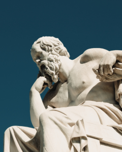 Marble statue of an ancient philosopher deep in thought, symbolizing wisdom, stoicism, and the pursuit of knowledge.